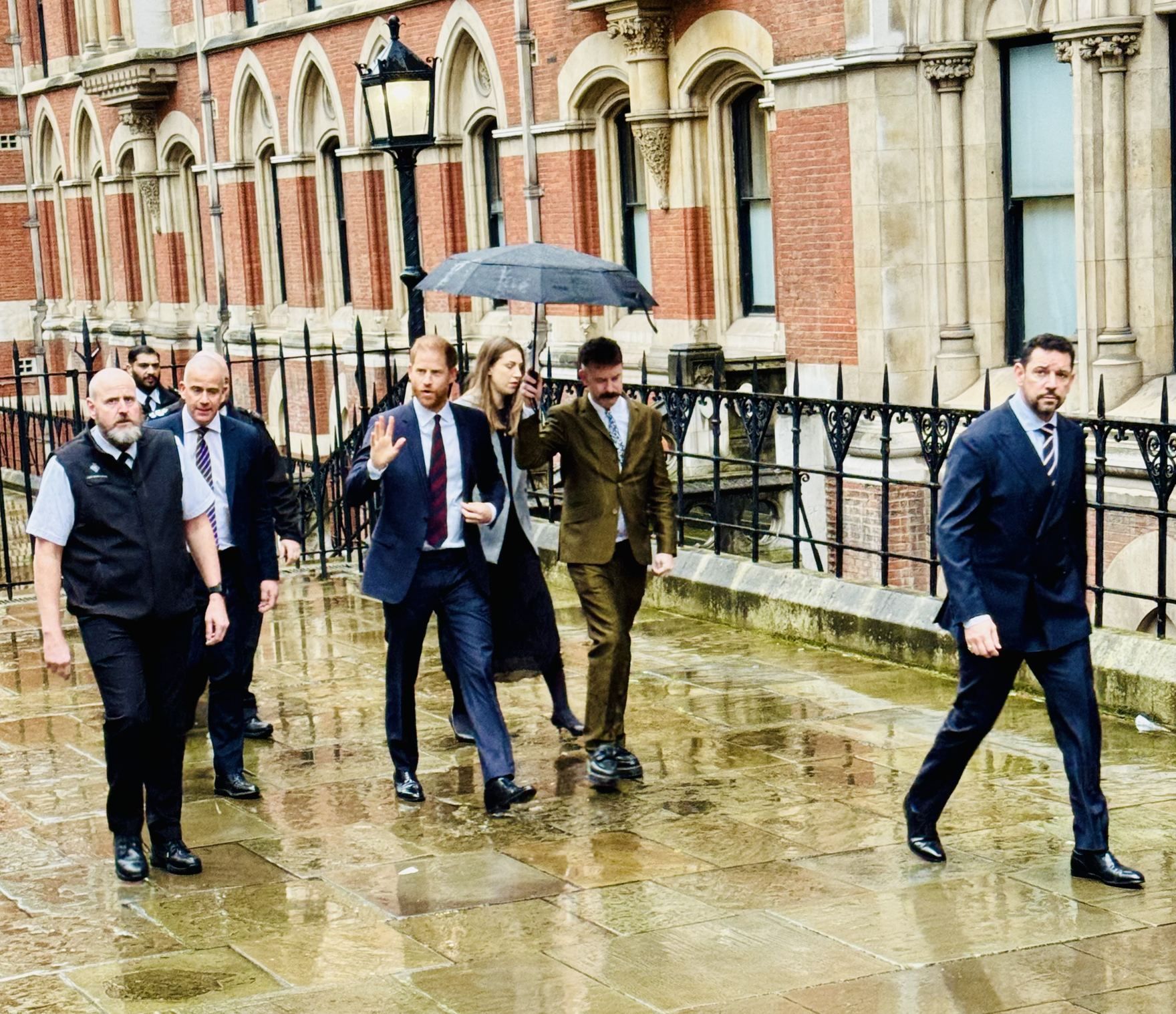 Accompanied by security and legal advisers, Prince Harry makes his way along the perimeter of the court building. Inside, lawyers continue the detailed cross-examination, focusing on sources, inference, and whether contemporaneous complaints were ever raised.