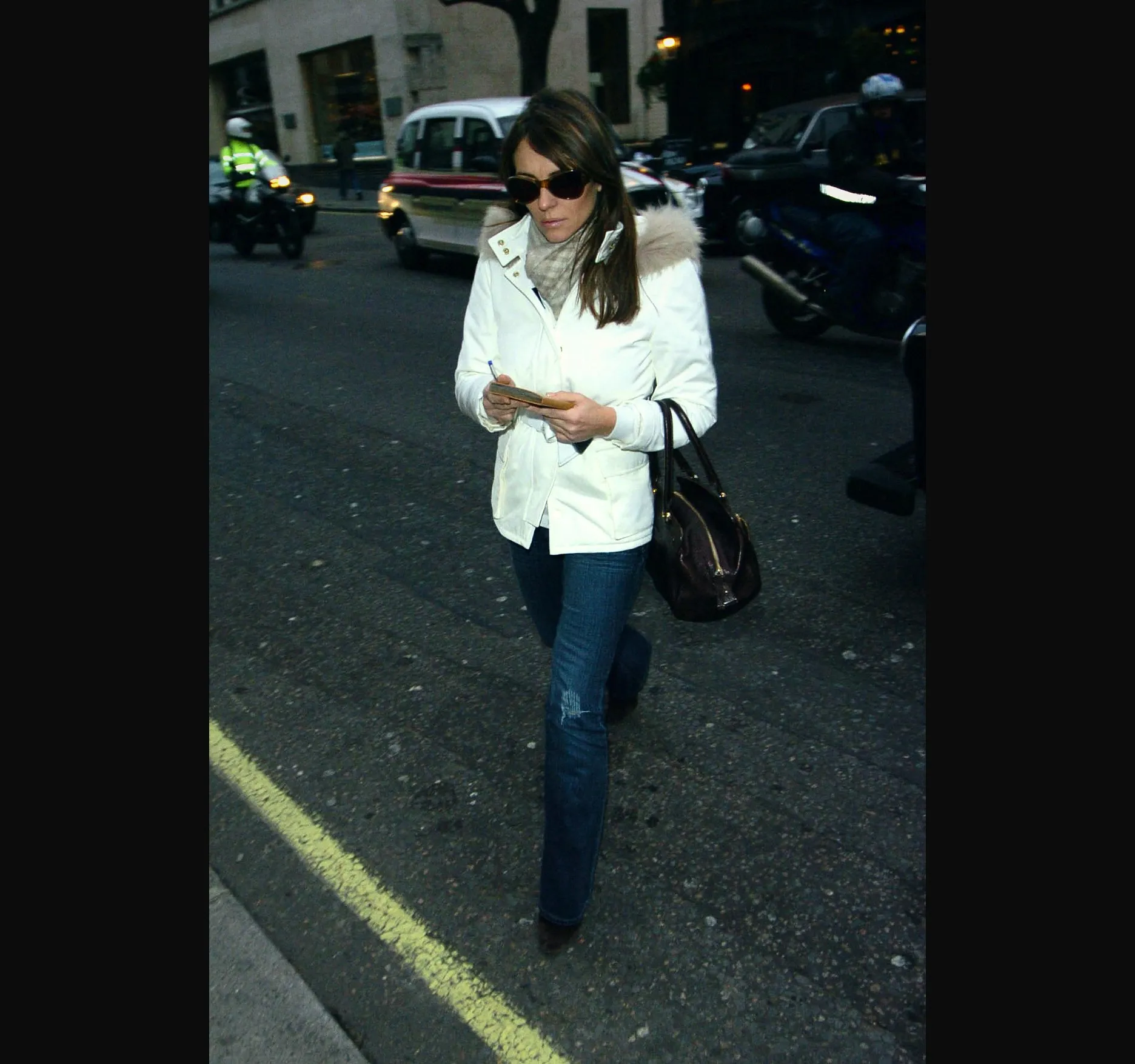 A frame from the same afternoon, a little further along, with a taxi and a van on the road behind her.