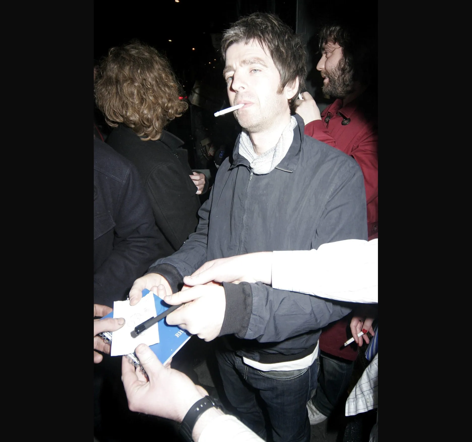 Fans and photographers crowd in as he leaves.