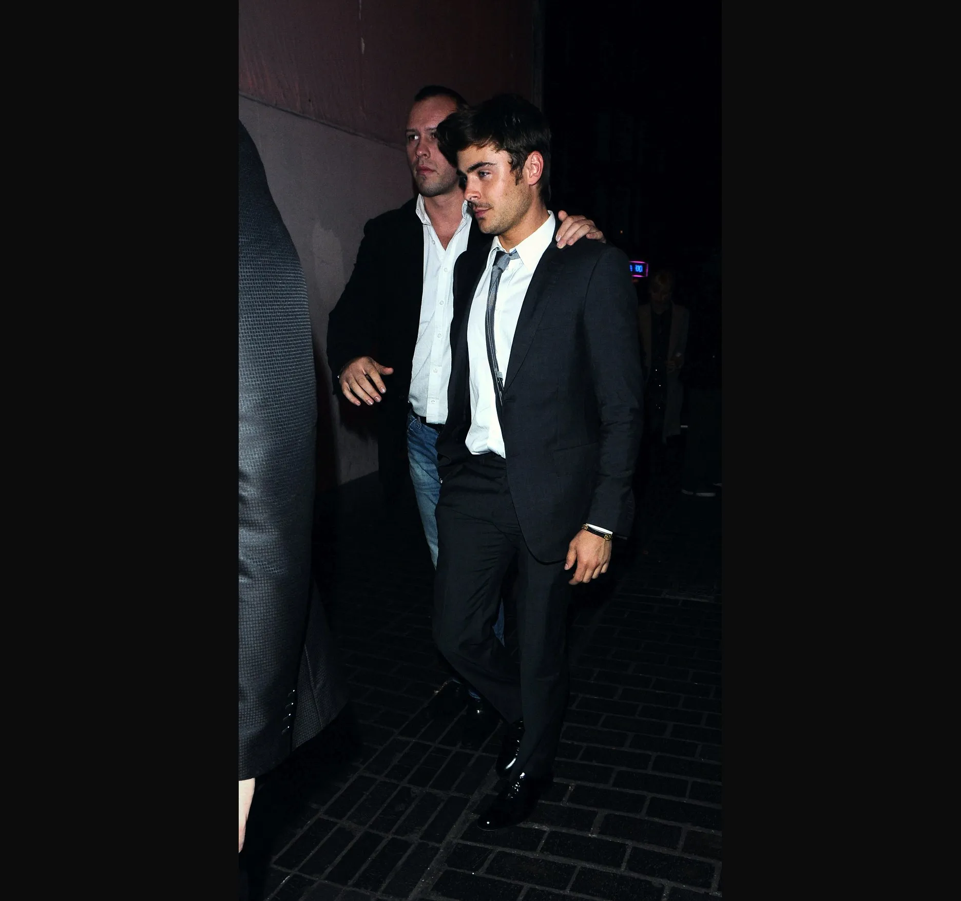 THE BOX, SOHO, OCTOBER 2011. Zac Efron outside The Box nightclub on Walker's Court, Soho, in the early hours of 21 October 2011, after the night of 20 October. He was out marking his 24th birthday. He wears a dark grey suit, white shirt and grey tie.