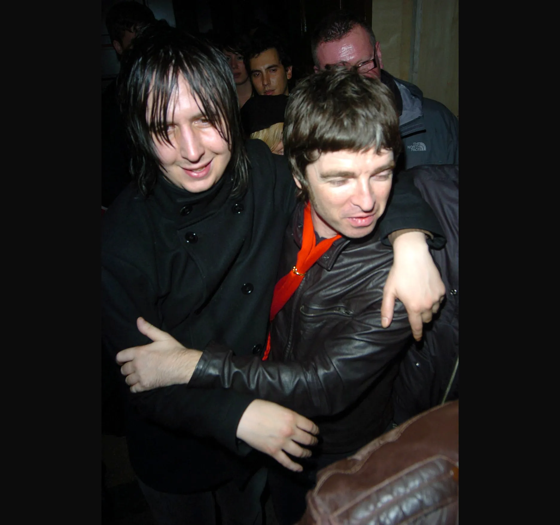 CUCKOO CLUB, NOVEMBER 2006. Noel Gallagher leaves the Cuckoo Club in London on the night of 20 November 2006, into the early hours of 21 November. His then girlfriend, Sara MacDonald, is with him. They married in 2011. Oasis were still together. Here is Noel stepping out into the night with an arm around his shoulder.