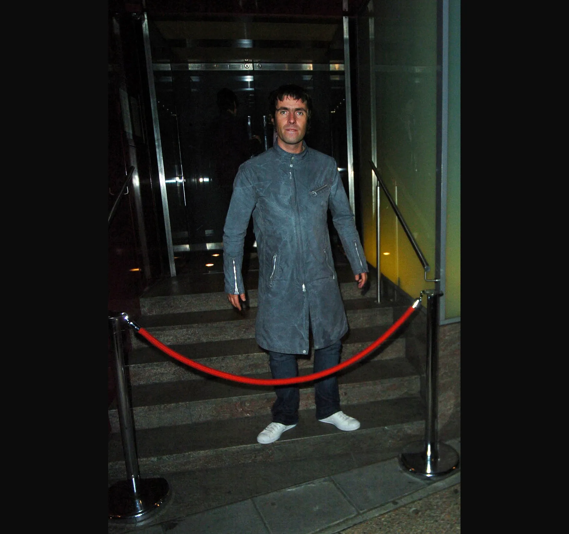 MET BAR, OCTOBER 2005. Liam Gallagher outside the Met Bar on Old Park Lane in Mayfair on the night of 10 October 2005. That day Oasis had won Best Album for Don't Believe the Truth and the People's Choice award at the Q Awards at Grosvenor House in London.

The People's Choice award went to Oasis because they had collected more votes across all the categories than any other act, 230,000 in all. Coldplay took Best Act in the World Today, and Gorillaz won Best Video and Best Producer.

The Met Bar, in the Metropolitan Hotel, was a celebrity haunt of the Britpop years. Here is Liam at the foot of the steps behind a red rope, in a blue grey zip coat, jeans and white trainers.