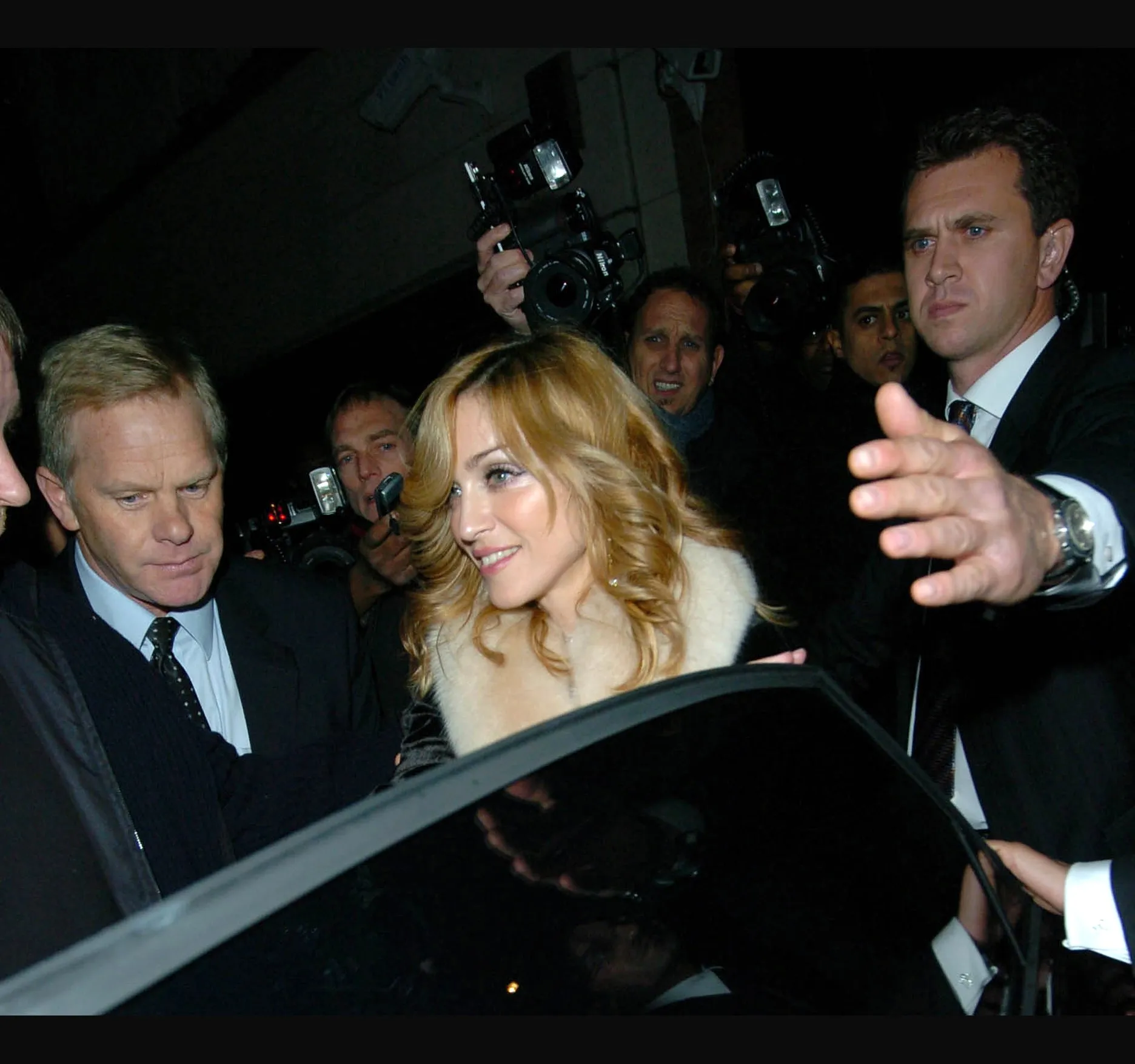Leaving in the early hours of 16 November, with a hand held out beside her and the cameras up as she reaches the car door.